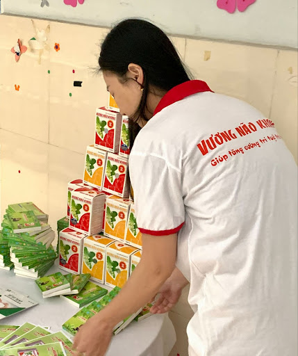 Đại diện nhãn hàng Vương Não Khang thuộc công ty Nam Phương nâng niu các phần quà nhỏ dành tặng cho các bé 
